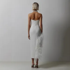 Elegant white strapless evening dress with luxurious ostrich feather trim and slit.