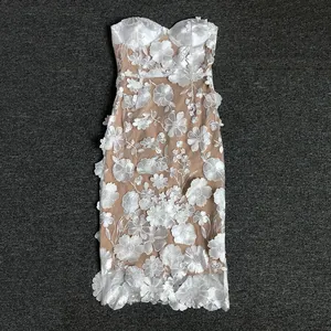 Detailed macro view of 3D lace floral appliqués on a white strapless banquet dress