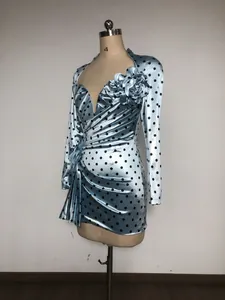 Detailed view of the 3D floral accent and ruched waist on a blue polka dot dress