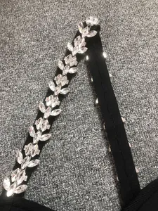 Detailed view of heavy marquise rhinestone chain on a premium black bandage dress shoulder strap