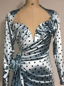 Detail view of light blue polka dot dress with elegant V-neck and 3D floral accents