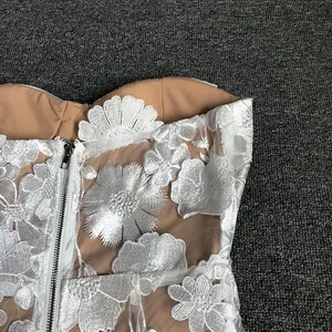 Detailed close-up showing the white 3D floral lace embroidery on a strapless dress.