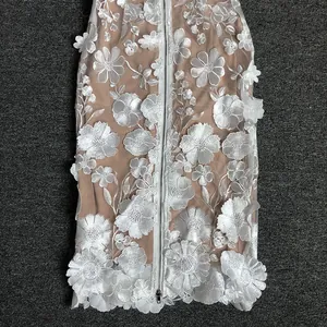 Detail of 3D white floral lace embroidery on a slim-fit elegant strapless dress