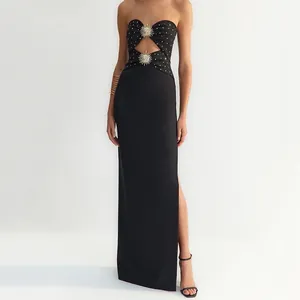 Front view detail of black strapless dress with sun-shaped hardware and high leg slit