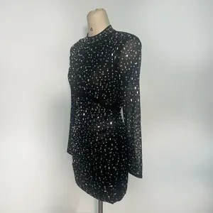 Close-up of a black mesh mini dress featuring sparkly silver rhinestone embellishments.
