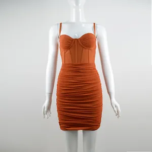 Dettaglio del mini abito a corsetto arancione ruggine con gonna a pieghe