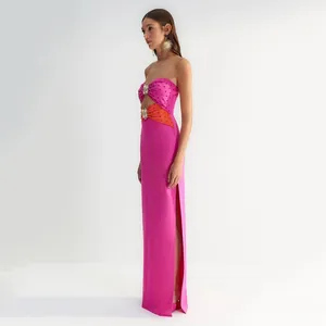 Close-up of pink strapless maxi dress with side slits and decorative metal sun accents