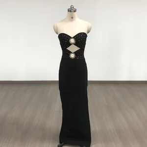Close-up detail of black strapless bandage gown featuring gold sun ornaments and rhinestones