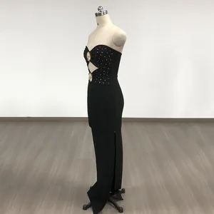 Elegant black strapless bandage maxi dress with gold studs and side slit detail.