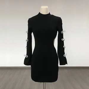 Detailed view of black bodycon dress featuring rhinestone bow accents and side waist cutout