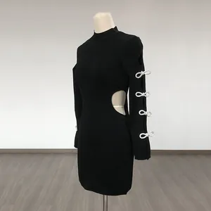 Side view of a black mini dress with waist cutout and sparkling rhinestone bow sleeve details.