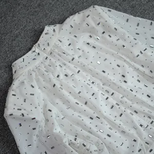 Detailed view of elegant white mesh fabric decorated with shimmering silver rhinestones