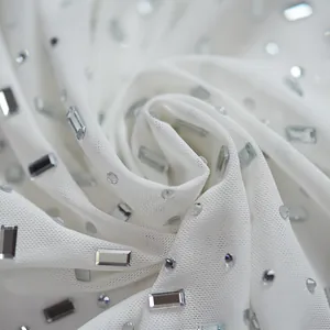 Macro view of white mesh fabric adorned with sparkling silver rhinestones and crystals