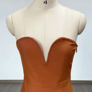 Nahaufnahme eines burnt orange Bandage-Kleides mit tiefem V-Ausschnitt und Rippenstruktur