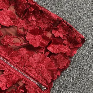Detailed close-up of red 3D floral embroidery and silver zipper on luxury evening dress