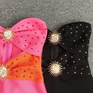 Close-up of strapless bandage dress with hot-drilled rhinestones and gold sunburst accessory.