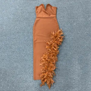 Detailansicht eines trägerlosen braunen Kleides mit elegantem Federbesatz am Saum