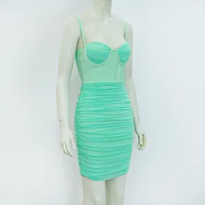 Dettaglio di un abito bodycon arricciato in rete verde menta con spalline sottili
