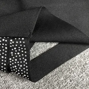 Close-up of black bandage fabric with sparkling silver rhinestone embellishments
