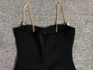 Detail of back zipper and gold rhinestone chain straps on sexy black bandage dress