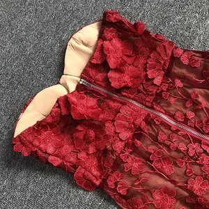 Close-up of elegant red lace evening dress with 3D flower appliques and zipper detail