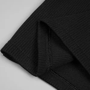 Close-up detail of black ribbed bandage fabric showing fine knit texture and hem