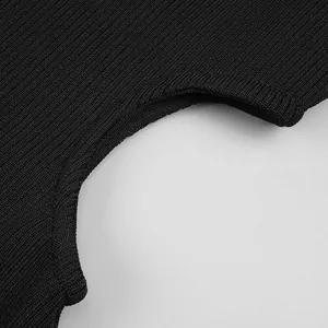 Macro shot of black ribbed knit bandage fabric showing detailed texture and cutout edge