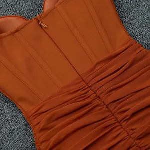 Primo piano di un abito a corsetto arancione-marrone con cerniera e tessuto in mesh arricciato