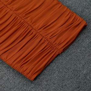 Vista dettagliata della trama del tessuto arancione increspato di alta qualità sul vestito.