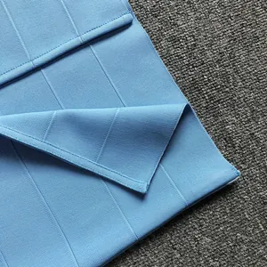 Close-up of high-elasticity light blue bandage fabric texture on an evening dress.