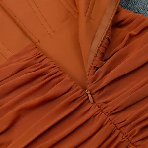 Dettaglio macro della cerniera invisibile e del tessuto a rete plissettato del vestito