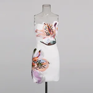 Detailed macro shot of white strapless mini dress featuring elegant lily floral embroidery