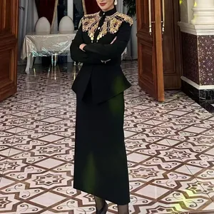 Elegante completo nero due pezzi con ricami dorati su modella in un lussuoso interno