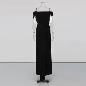 Detail view of a black pleated off-shoulder long dress with a sleek high waist silhouette