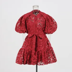 Detailed view of red hollow-out jacquard dress with puff sleeves and bow belt