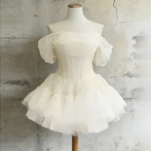 Detailansicht der Netzrüschen und des Korsett-Bodys an einem weißen Minikleid mit Puffärmeln