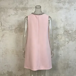Elegant back view of pink sleeveless dress with rhinestone collar on clear mannequin.