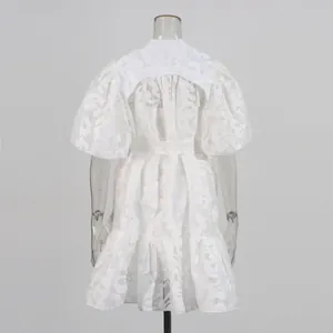 Back view of white puff sleeve mini dress featuring hollow jacquard and waist tie