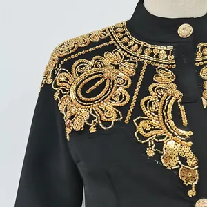 Primo piano di perline e paillettes dorate su una giacca nera elegante stile cinese.