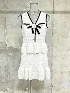 Completo due pezzi in maglia bianca con top senza maniche e minigonna con volant