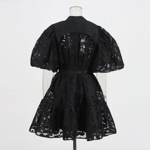 Back view of a black puff sleeve dress with elegant hollow-out lace jacquard patterns