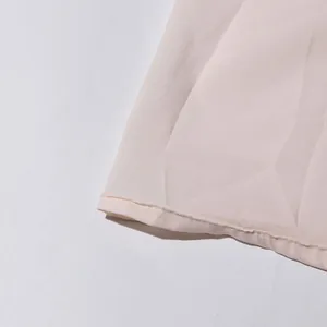 Détail en gros plan de l'ourlet et des coutures d'une robe de vacances française rose clair