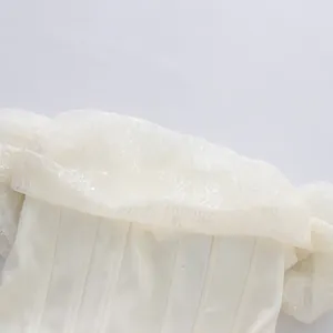 Makroaufnahme des schulterfreien Netzkleids mit Spitzenmuster und Fischgrätenstruktur.
