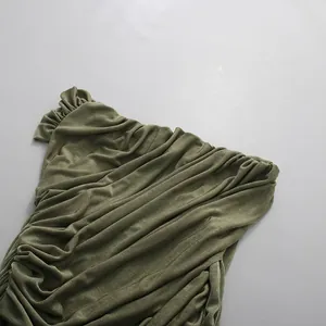Detail of olive green ruched fabric showing elegant pleated texture for a chic dress.