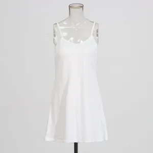 Minimalist white spaghetti strap slip dress shown on a transparent mannequin display