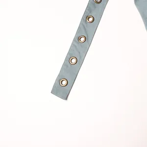Vista dettagliata della cinghia con occhielli metallici sui jeans cargo blu chiaro