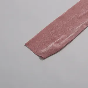 Close-up macro view of shimmer pink pleated fabric detail for elegant long beach dress