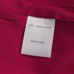 Detail view of clothing care label showing 100% polyester material composition info.