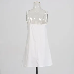 Rear view of a minimalist white spaghetti strap slip dress on a mannequin