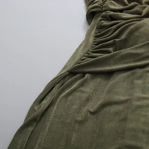 Macro view showing the elegant ruched detail and textured fabric of the green maxi dress